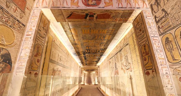 Ein schmaler Korridor mit Hieroglyphen an den Wänden und einer verzierten Decke.