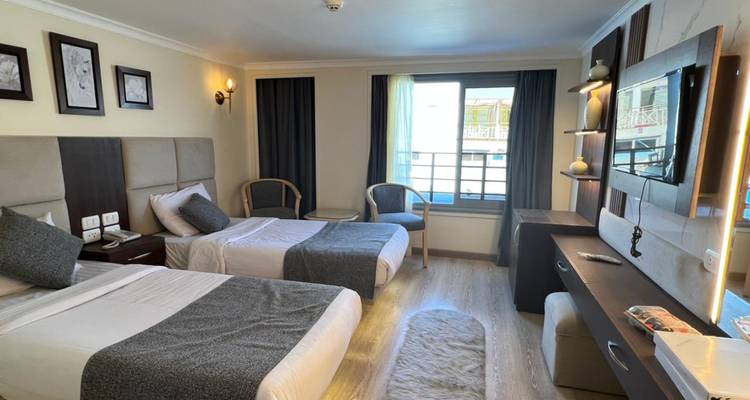 Simple twin room on a river cruise boat with window and light wooden flooring