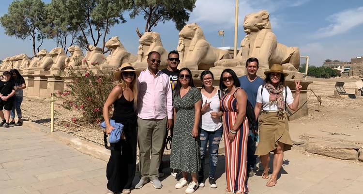 Tour group posing by a row of sphinx statues on the Avenue of Sphinxes in Luxor