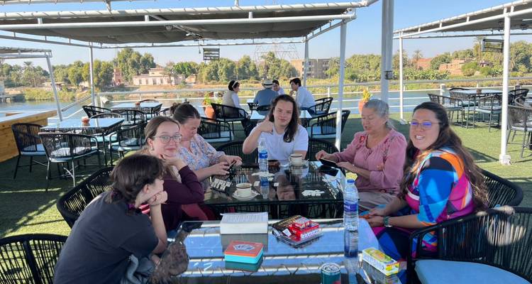 Travel companions chatting at an outdoor lounge area on a cruise ship overlooking the Nile