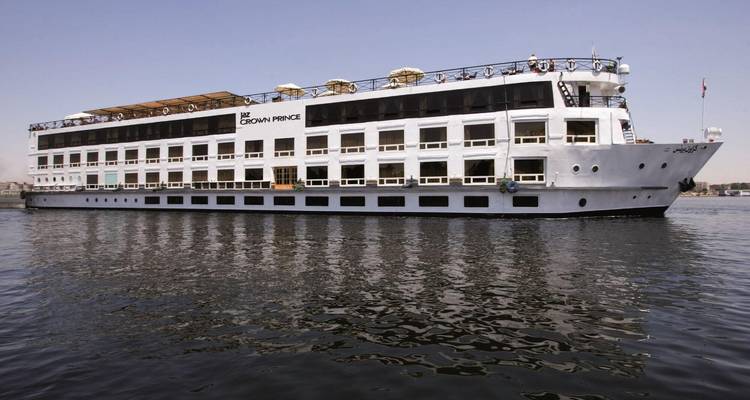 Un grand bateau de croisière fluviale avec plusieurs ponts sur une étendue d'eau calme.