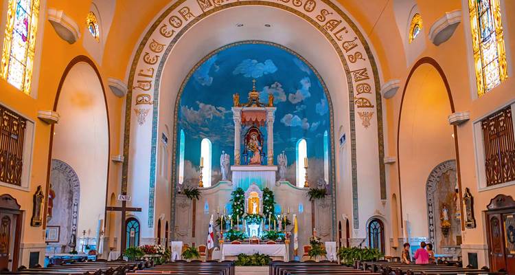 Interior de una iglesia grandiosa con techos altos e iconos religiosos.