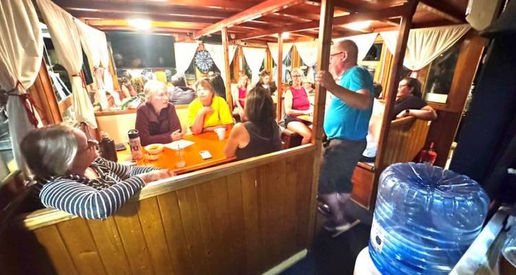 Groupe de personnes dans un coin repas confortable à l'intérieur d'un bateau.