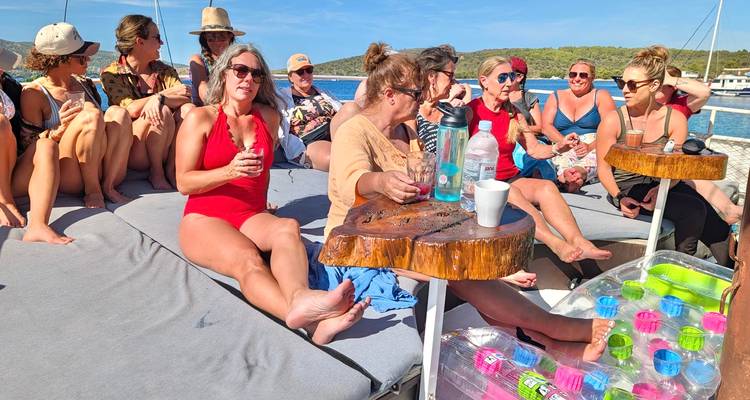 Groupe de personnes se prélassant sur un bateau avec des boissons.