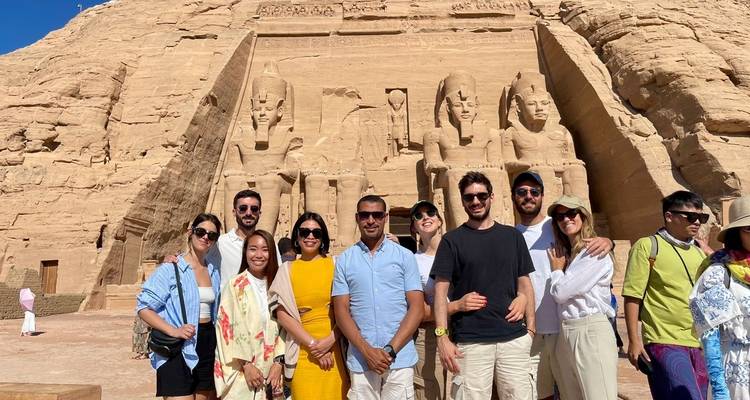 Eine Gruppe von Touristen in Abu Simbel, die vor den großen Statuen posiert.
