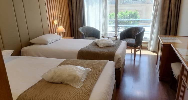 Hotelzimmer mit Einzelbett, modernen Annehmlichkeiten und Balkonblick.