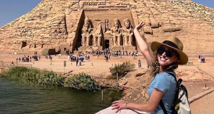 Tourist posiert vor den Abu Simbel Tempeln am Wasser.