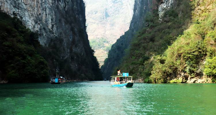 Boot die door een smalle rivierkloof met hoge rotswanden navigeert.