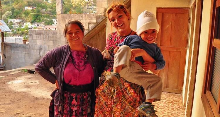Une famille posant pour une photo sur un balcon avec un paysage montagneux.