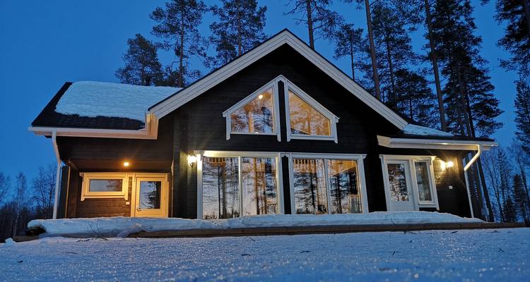Schneebedecktes Haus im Abendlicht.