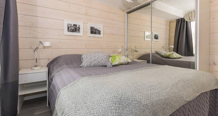 Schlafzimmer mit neutralen Tönen und verspiegeltem Kleiderschrank.