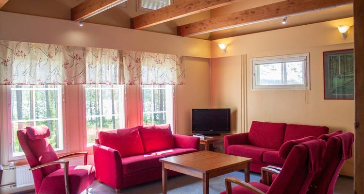 Wohnzimmer in warmen Farben mit roten Möbeln.