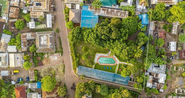 Aerial view of a green area with a pool and buildings.