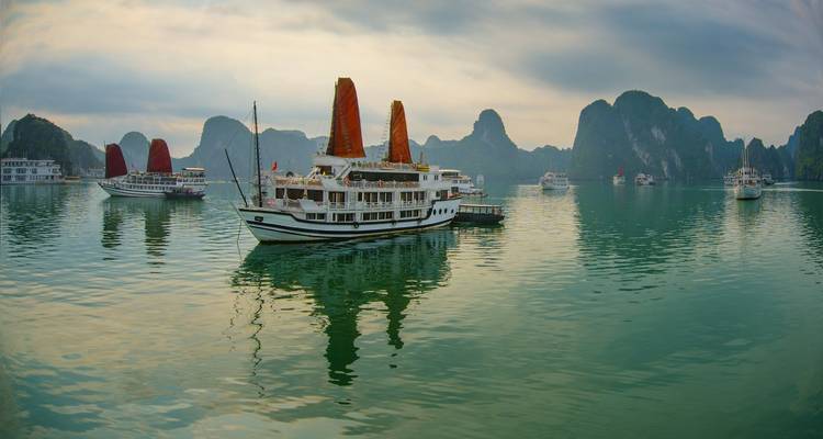 Cruiseboten in een schilderachtige baai omringd door kalkstenen karst.