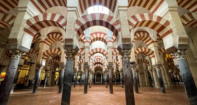 Gewölbte rot-weiß gestreifte Säulen des Inneren der Mezquita-Kathedrale in Córdoba