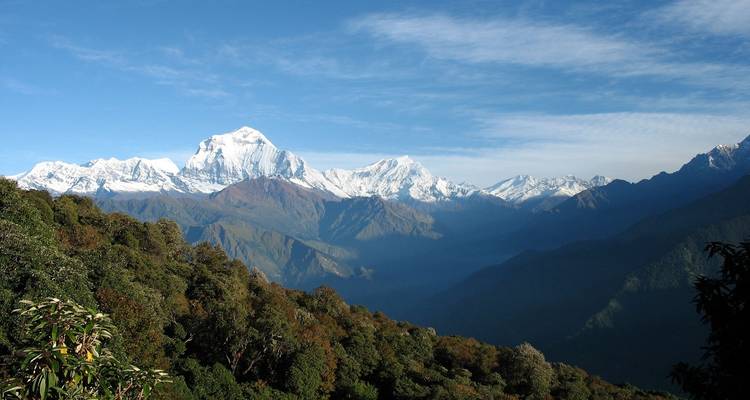 Vue panoramique d'une chaîne de montagnes aux sommets enneigés.