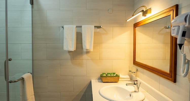 Moderne badkamer met handdoekenrek en grote spiegel.