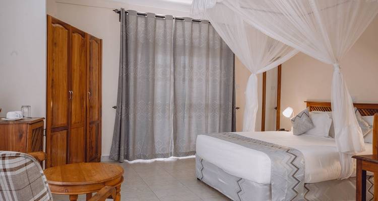 Elegante slaapkamer met een hemelbed en houten decoratie.