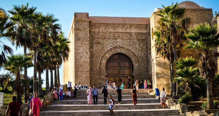 Personas en la entrada de un edificio histórico ornamentado.