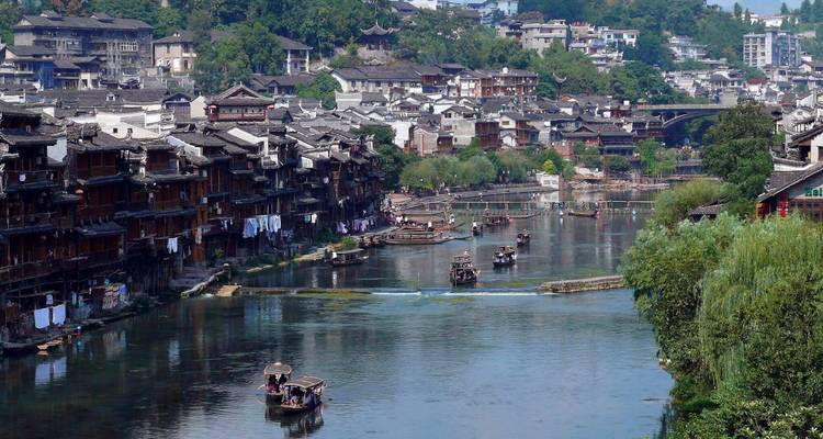 Historische Flussstadt mit Booten und traditioneller Architektur.