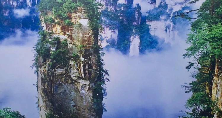 Karstgipfel, die durch Nebel in einer dramatischen Landschaft aufragen.