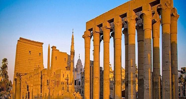 Stenen zuilen en oude ruïnes van de Luxor Tempel verlicht door zonlicht.