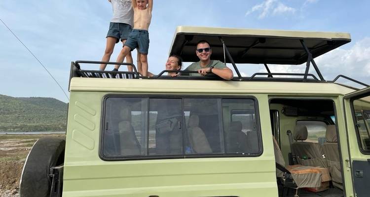 Familie genießt eine Safari-Fahrt in einem Fahrzeug mit offenem Dach.