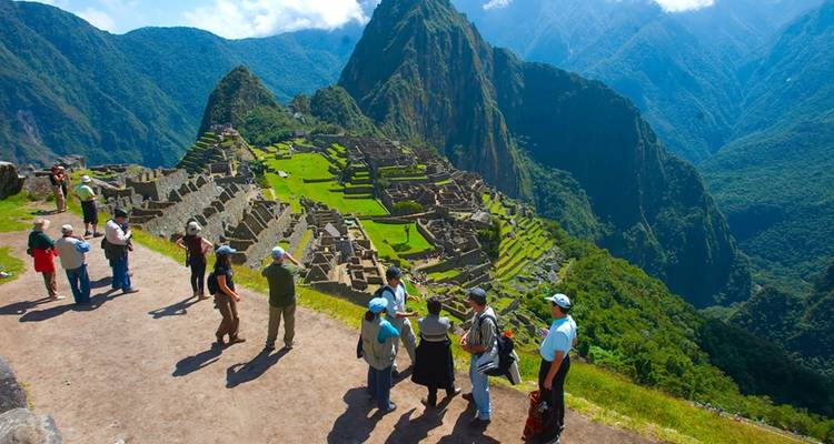 Toeristen die de ruïnes van Machu Picchu bekijken vanaf een schilderachtig uitkijkpunt.