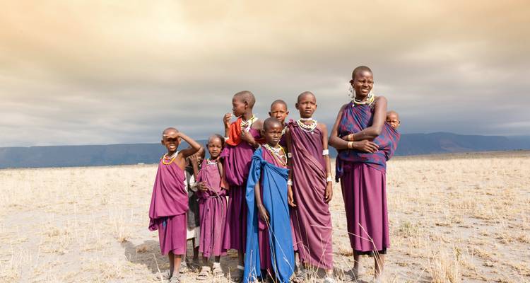 Een groep mensen in traditionele kleding poserend op een grasvlakte.