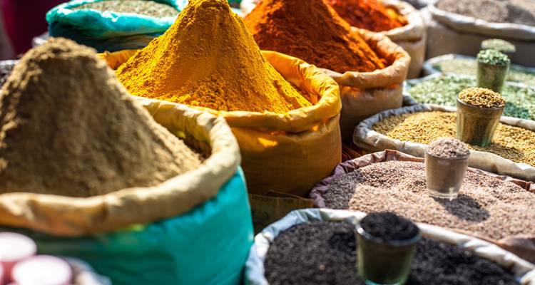Kleurrijke kruiden uitgestald op een markt.