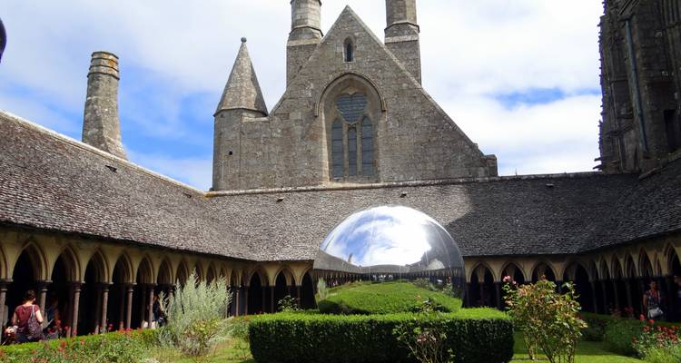 Kloostertuin met reflecterende bol in een historische abdij.