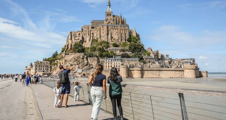 Bezoekers die over een loopbrug naar de Mont Saint-Michel lopen.