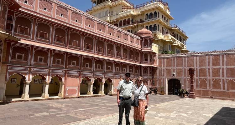 Una pareja posando frente al patio de un gran palacio.