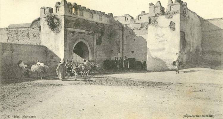 Vintage Sepia-Foto von pferdegezeichneten Karren, die durch ein befestigtes Tor von Marrakesch einfahren.