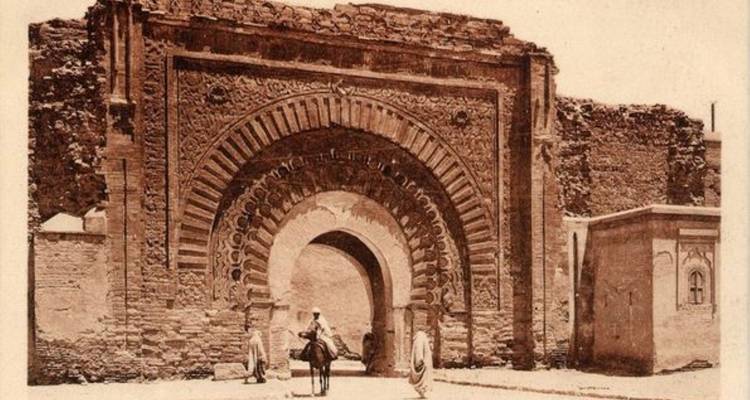 Historisches getöntes Foto des verzierten gewölbten Bab Mansour-Tors mit Reitern in der Nähe.