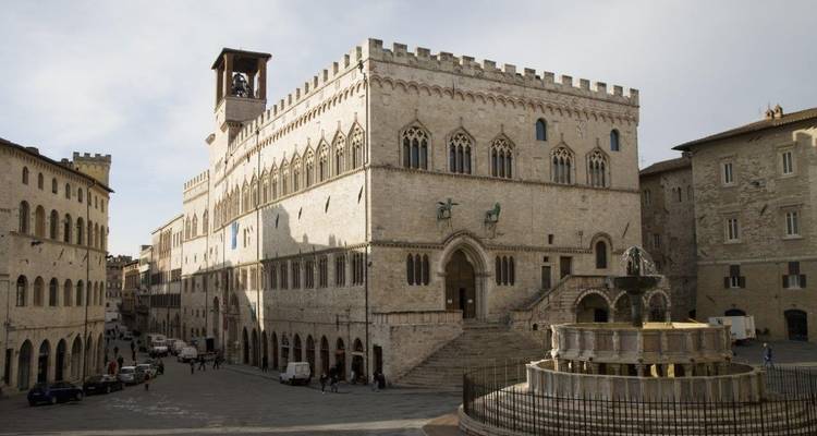 Un bâtiment historique et une fontaine sur une place de ville italienne.