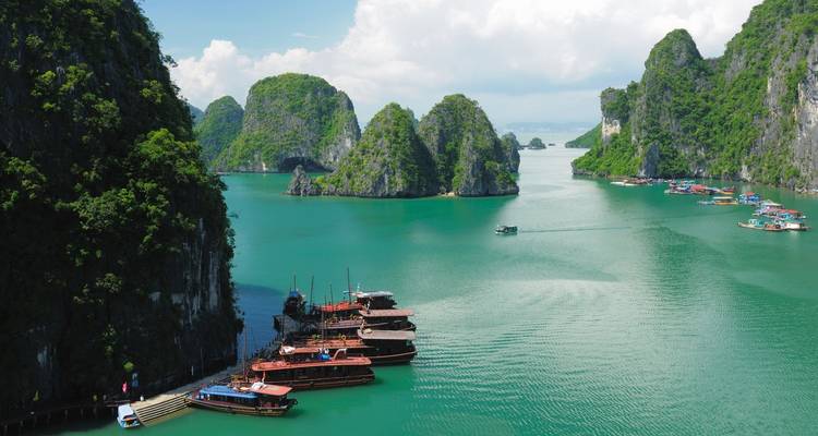Karst de caliza y barcos en una bahía serena.