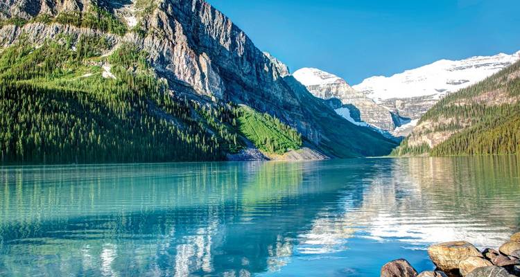 Lake Louise mit klarem türkisfarbenem Wasser, umgeben von Bergen.