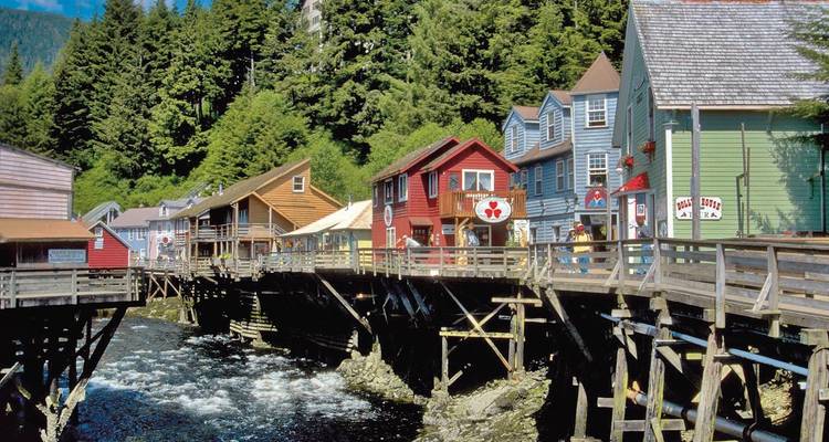 Kleurrijke huizen op palen langs een waterkant.
