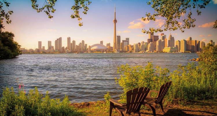 Vue de l'horizon de Toronto avec la Tour CN depuis l'autre côté du lac, observée depuis un cadre de parc tranquille.