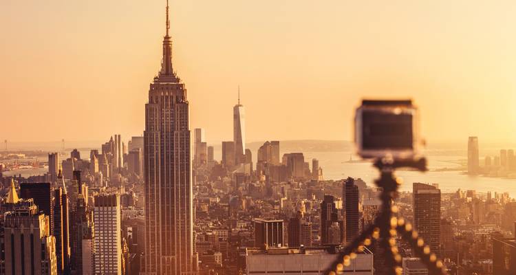 New York City skyline at golden hour with tripod in view.