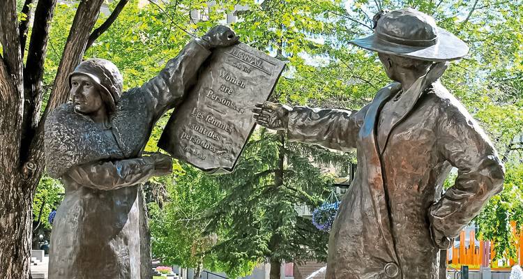 Statues représentant des personnages historiques dans un parc.