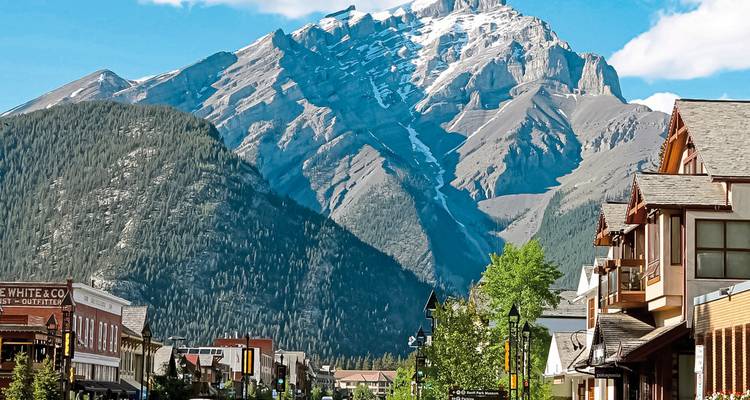 Rue animée de la ville avec des montagnes en arrière-plan.