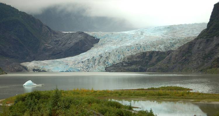 Glacier rencontrant un lac entouré de montagnes.