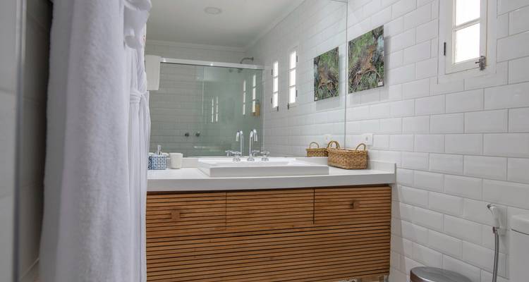 Intérieur de salle de bain moderne avec un grand miroir et un meuble-lavabo en bois.
