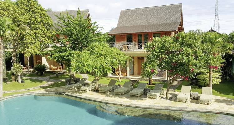 Resort con piscina y vegetación tropical.