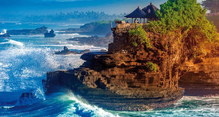 Ikonischer Küstentempel auf einer Klippe, umgeben von tosenden Wellen.