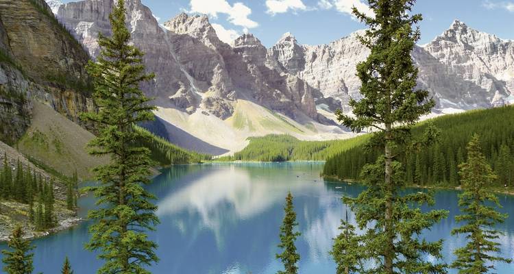 Turkooise meer met omringende bergen en bomen.