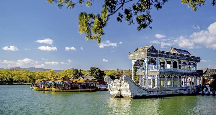 Verziertes Marmorboot auf einem See mit traditioneller chinesischer Architektur.