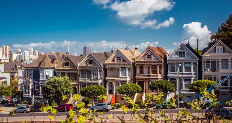Bunte Reihenhäuser in San Francisco unter einem blauen Himmel.
